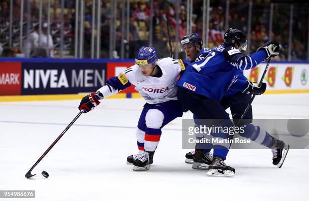 Teuvo Teravainen of Finland and Kisung Kim of Korea battle for the puck during the 2018 IIHF Ice Hockey World Championship group stage game between...