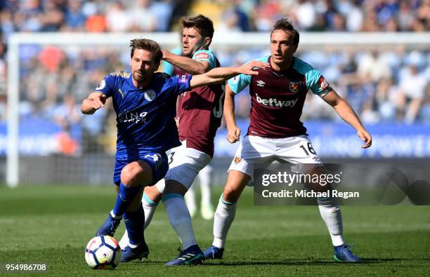 Adrien Silva of Leicester City controls the ball as Mark Noble of West Ham United and Aaron Cresswell of West Ham United looks on during the Premier...