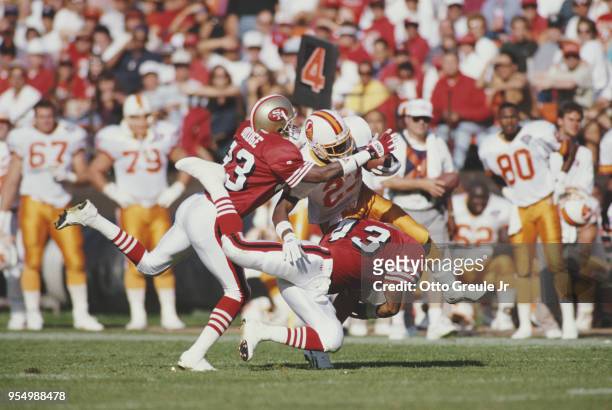 Marty Carter, Strong Safety for the Tampa Bay Buccaneers is tackled by Marc Logan and Dedrick Dodge of the San Francisco 49ers during their National...