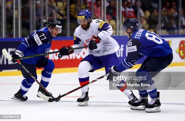 Teuvo Teravainen and Markus Nutivaara of Finland and Alex Plante of Korea battle for the puck during the 2018 IIHF Ice Hockey World Championship...