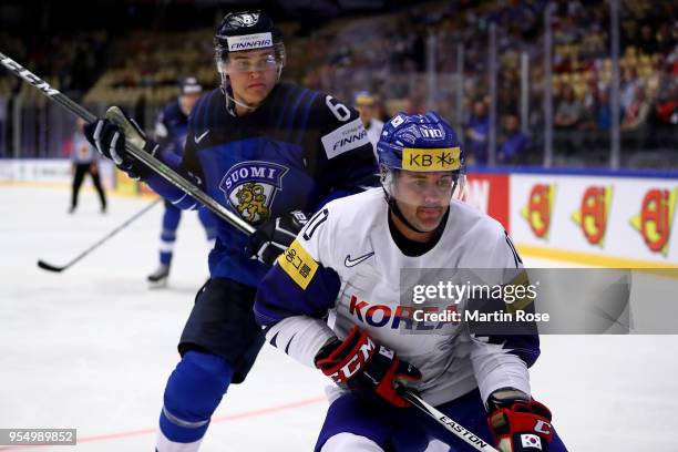 Julius Honka of Finland and Michael Swift of Korea battle for the puck during the 2018 IIHF Ice Hockey World Championship group stage game between...