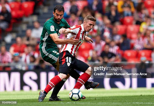 Jordi Amat of Real Betis competes for the ball with Iker Muniain of Athletic Club during the La Liga match between Athletic Club Bilbao and Real...