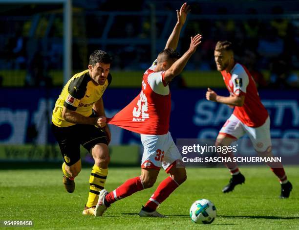 Dortmund's Greek defender Sokratis Papastathopoulos pulls the shirt of Mainz's Argentinean forward Pablo De Blasis during the German first division...