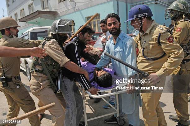 Police try to take the body of a civilian, Adil Ahmed from relatives and locals, at a local hospital, on May 5, 2018 in Srinagar, India. Adil was...