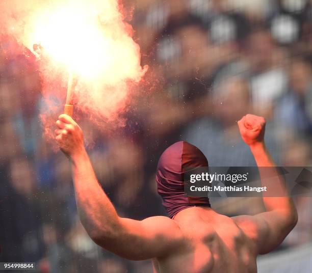 Supporter of Hamburg lights a flare during the Bundesliga match between Eintracht Frankfurt and Hamburger SV at Commerzbank-Arena on May 5, 2018 in...