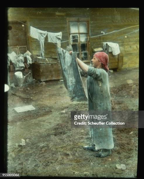 Woman hanging laundry on clothesline, A young woman hangs wet laundry on a clothesline. USSR, circa 1919-1925, circa 1919-1925, USSR.