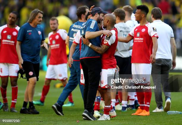 Head coach Sandro Schwarz of Mainz celebrates with Nigel de Jong of Mainz avoiding the relegation after winning 2-1 the Bundesliga match between...