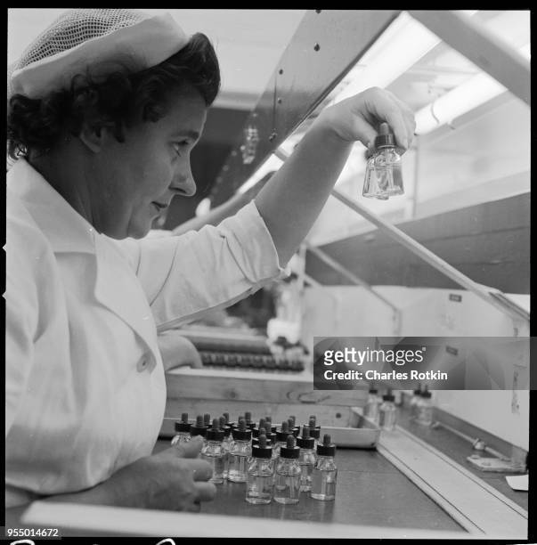 Worker examines finished pharmaceuticals, A worker in a sterile area of the Pfizer pharmaceutical plant in Folkstone, England, visually examines...