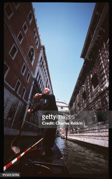 Gondolier, A gondolier maneuvers his boat as it passes under the Bridge of Sighs on the Grand Canal, June 1965, Venice, Italy.