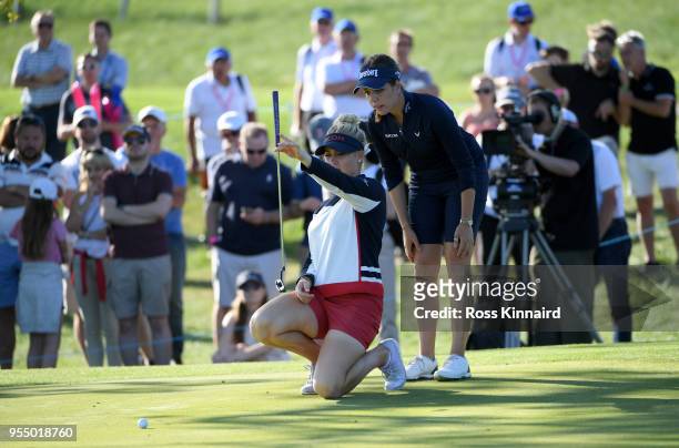 Charley Hull of England Women lines up a putt on the fifth green as Georgia Hall of England Women looks over her shoulder during Day One of the...