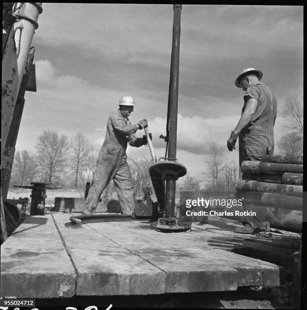 Plugging oil wells, Workers at a Texaco refinery plug and flood oil wells with water, circa 1957, Illinois, USA.