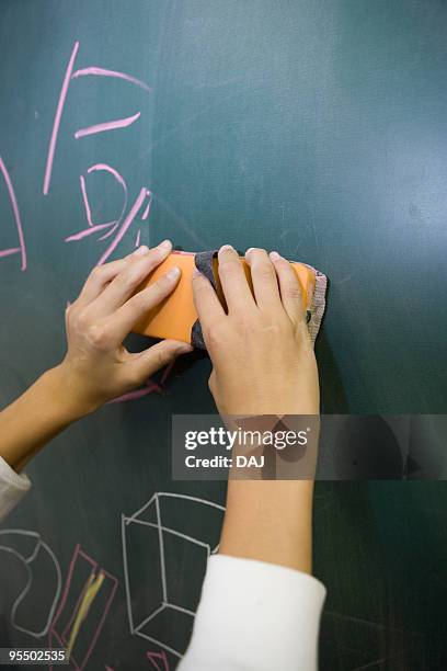 students erasing words on blackboard - chalkboard eraser stock pictures, royalty-free photos & images