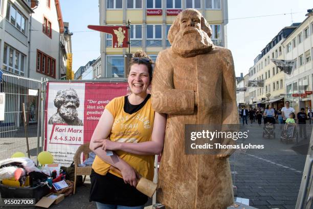 Artist Dana van Rijssen pictures with her wooden sculpture of German philosopher and revolutionary Karl Marx on the 200th anniversary of the birth of...