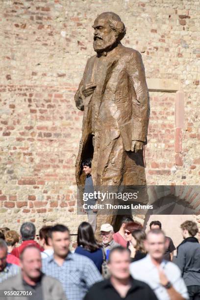 Visitors take pictures in front of sculpture of German philosopher and revolutionary Karl Marx on the 200th anniversary of the birth of Karl Marx on...