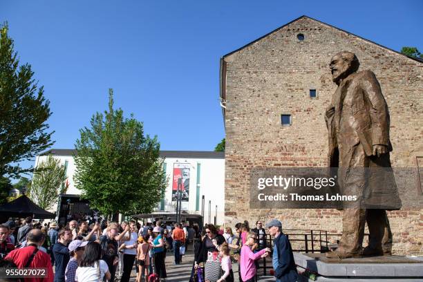 Visitors take picutres in front of sculpture of German philosopher and revolutionary Karl Marx on the 200th anniversary of the birth of Karl Marx on...