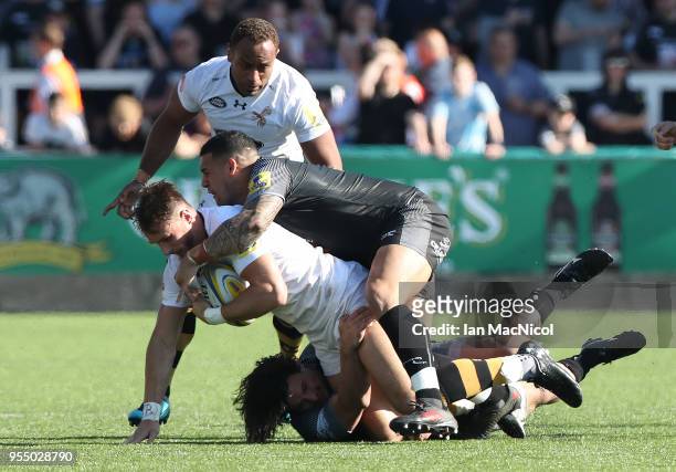 Josh Bassett of Wasps is tackled by Juan Pablo Socino and Santiago Socino of Newcastle Falcons during the Aviva Premiership match between Newcastle...