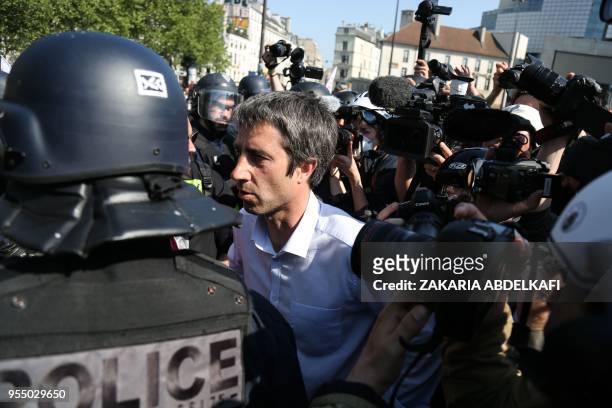 French leftist party "La France Insoumise" MP Francois Ruffin stands with French police officers next to a vandalised Franceinfo media vehicle as...