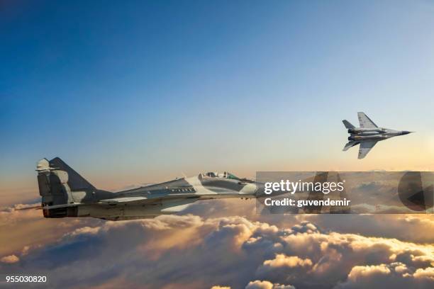 mig-29 fighter jets in volo sopra le nuvole al tramonto - aereo militare foto e immagini stock