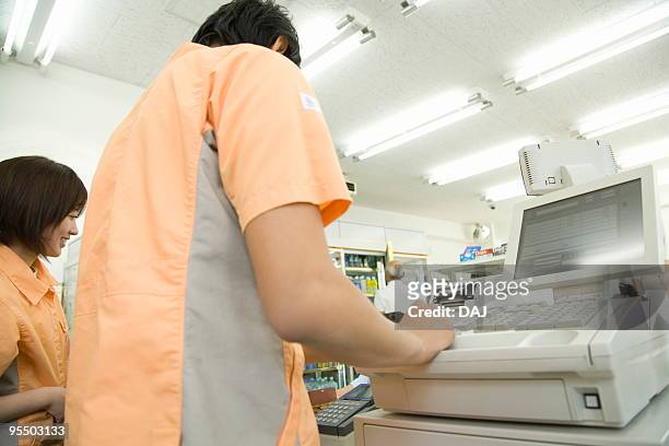 cashier at cash register - コンビニ ストックフォトと画像