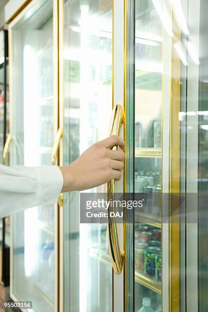 young woman trying to open the refrigerator - hand open convenience store refrigerator stockfoto's en -beelden