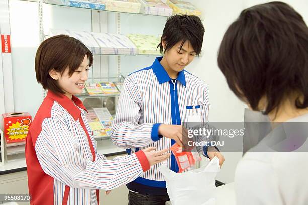 customer at checkout counter - コンビニ ストックフォトと画像