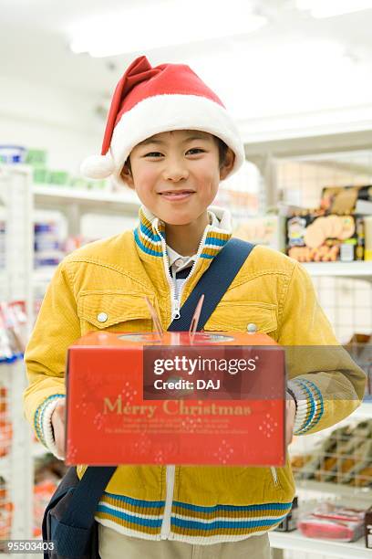 portrait of boy holding christmas cake at convenience store - itabashi ward stock pictures, royalty-free photos & images