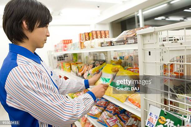 store clerk arranging merchandise - コンビニ ストックフォトと画像
