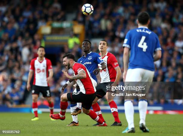 Charlie Austin of Southampton collides with Idrissa Gueye of Everton as Oriol Romeu of Southampton looks on during the Premier League match between...