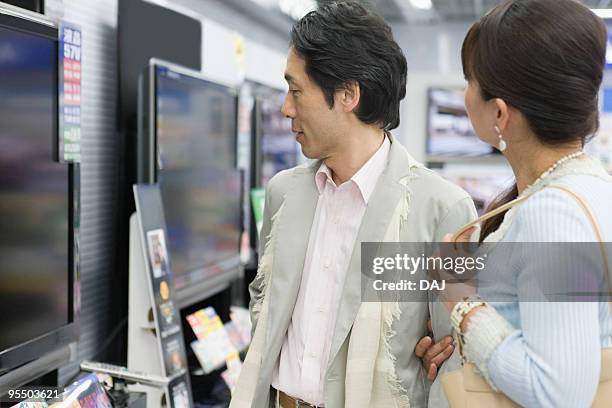 a couple looking for tv - lcd tv stock pictures, royalty-free photos & images