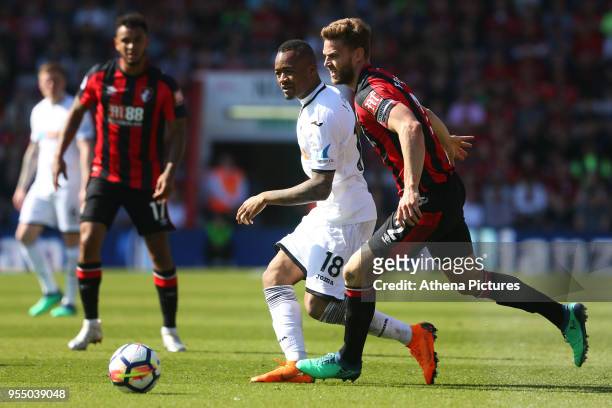 Jordan Ayew of Swansea City is marked by Simon Francis of Bournemouth during the Premier League match between AFC Bournemouth and Swansea City at...