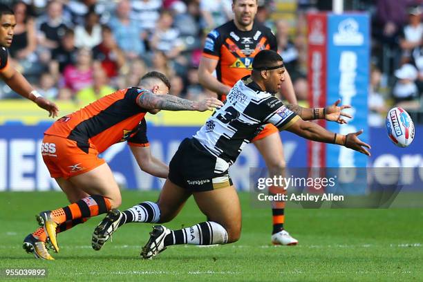 Mickey Paea of Hull FC passes the ball as Jamie Ellis of Castleford Tigers tackles him during the Betfred Super League match between Hull FC and...