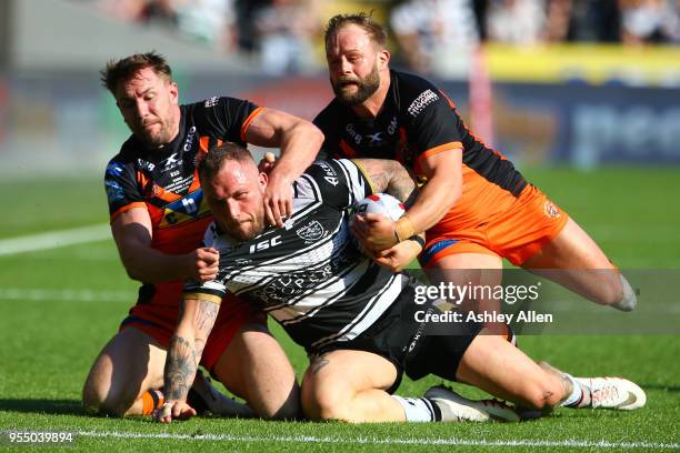 Josh Griffin of Hull FC is tackled by Michael Shenton and Paul McShane of Castleford Tigers during the Betfred Super League match between Hull FC and...