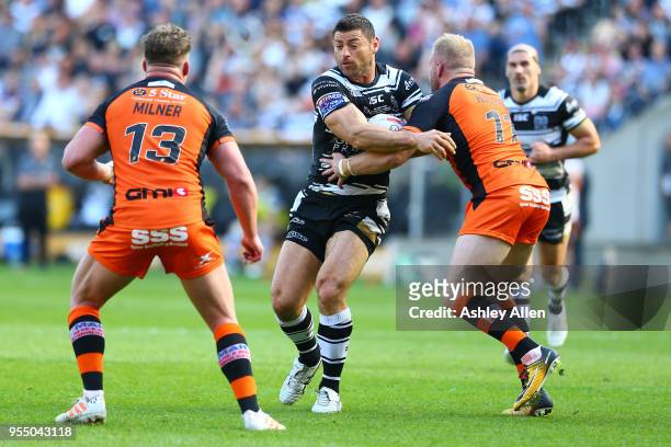 Mark Minichiello of Hull FC is challenged by Oliver Holmes and Adam Milner of Castleford Tigers during the Betfred Super League match between Hull FC...