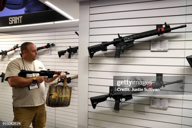 An attendee inspects a rifle during the NRA Annual Meeting & Exhibits at the Kay Bailey Hutchison Convention Center on May 5, 2018 in Dallas, Texas....