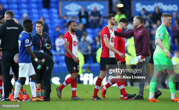 Wesley Hoedt of Southampton is embraced by Kelvin Davies as he walks off the pitch after the Premier League match between Everton and Southampton at...