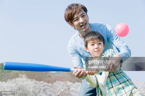 father and son holding bat together - japanese baseball players strike stock pictures, royalty-free photos & images