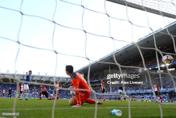 Alex McCarthy of Southampton looks on as Tom Davies of Everton scores his sides first goal during the Premier League match between Everton and...