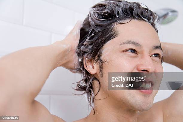 young man washing hair - shampoo ストックフォトと画像