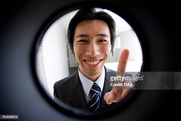 mid adult businessman outside the front door - peephole bildbanksfoton och bilder