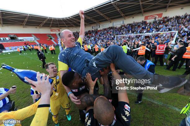 Paul Cook manager of Wigan Athletic is lofted in the air as they celebrate becoming League 1 Champions during the Sky Bet League One match between...