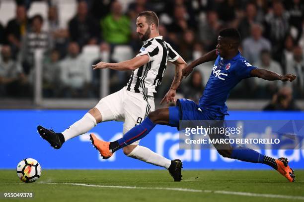 Juventus' Argentinian forward Gonzalo Higuain fights for the ball with Bologna's Malian midfielder Cheick Keita during the Italian Serie A football...