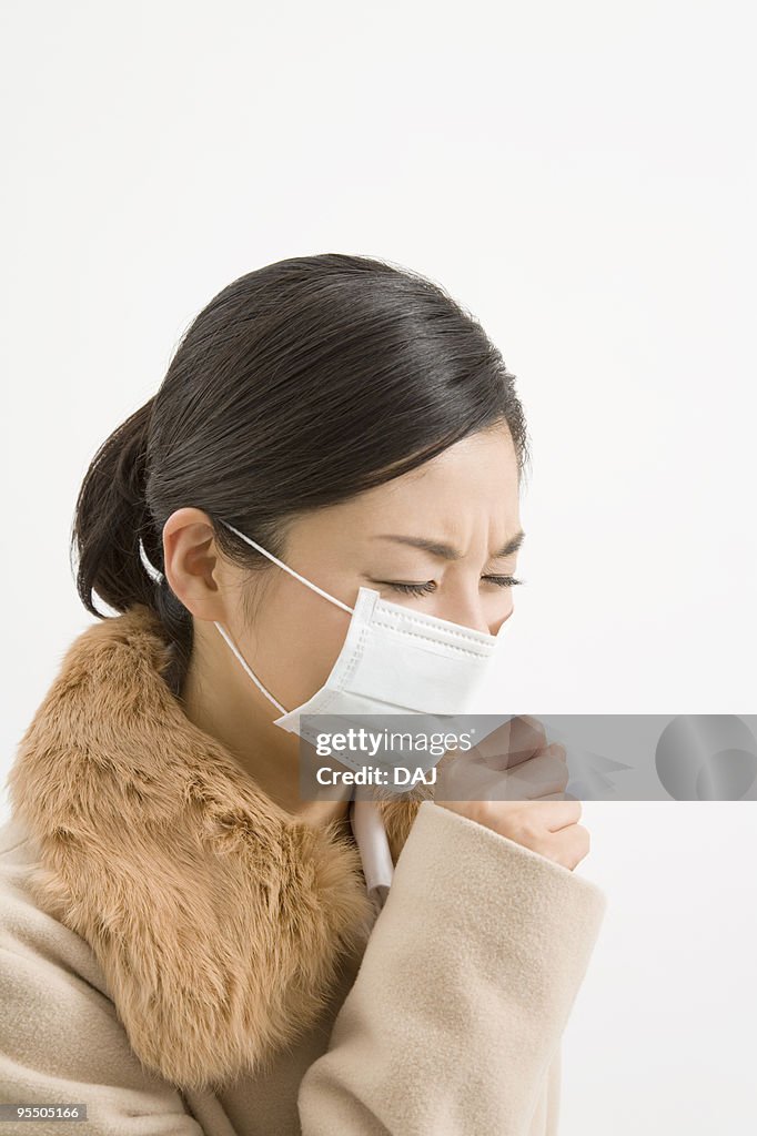Woman wearing a mask coughing