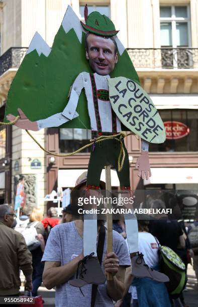 Protester holding a placard takes part in a protest dubbed a "Party for Macron" against the policies of the French president on the first anniversary...