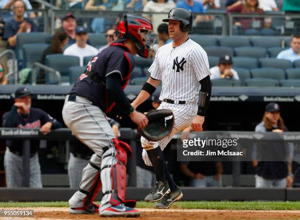 Austin Romine of the New York Yankees scores a run in the seventh inning past Roberto Perez of the Cleveland Indians at Yankee Stadium on May 5, 2018...