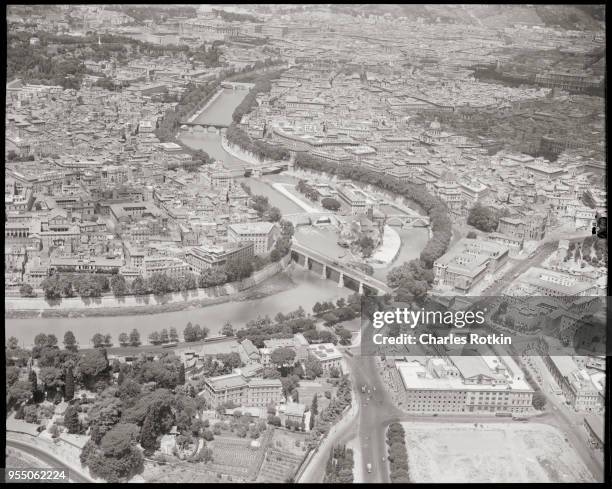 Aerial view centers upon tiber and isola tiberina, ponte palatino, temple of hercules victor, circa 1950, Rome, Italy.