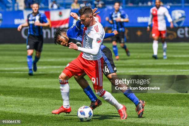 New England Revolution defender Gabriel Somi pushes Montreal Impact midfielder Raheem Edwards away while maintaining control of the ball during the...