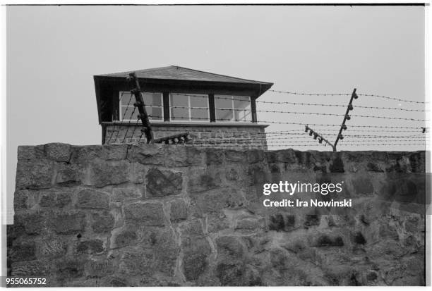 Electric fence and guard tower, A guard tower rises above an electric stone fence at Mauthausen, a Nazi concentration camp in operation during World...