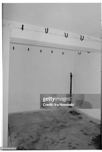 Cellar room in buchenwald crematorium, Iron meat hooks protrude grimly from the whitewashed walls of a bare cellar room at Buchenwald's crematorium....