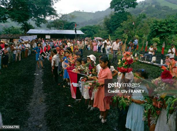 Enfants tenant des bouquets de fleurs lors d'un meeting du ?Front sandiniste de libération nationale? à Managua, en 1985, Nicaragua.