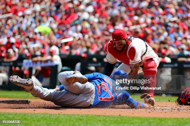 Addison Russell of the Chicago Cubs scores a run against Yadier Molina of the St. Louis Cardinals in the second inning at Busch Stadium on May 5,...